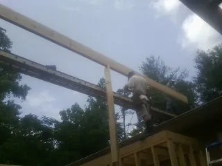 Carpenter setting a ridge beam over a new addition frame — Ice Dam Removal by Roofing Brothers in Skaneateles Falls