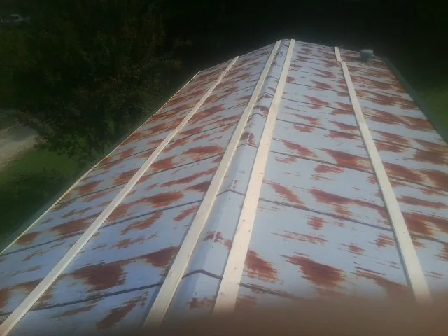 Rusted metal roof panels with new wood purlins before replacement — Storm Damage Roof Repair in Skaneateles Falls by Roofing Brothers