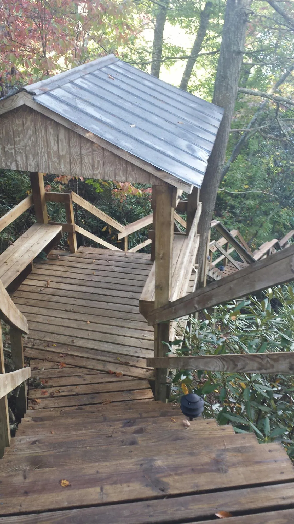 Metal roofed shelter over wooden steps on a wooded walkway — Skylight Repair & Installation work by our crew in Skaneateles Falls