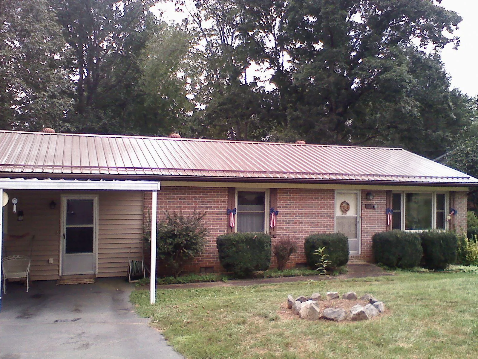 Bronze metal roof and carport on a brick ranch home — Roof Repair work by our crew in Skaneateles Falls