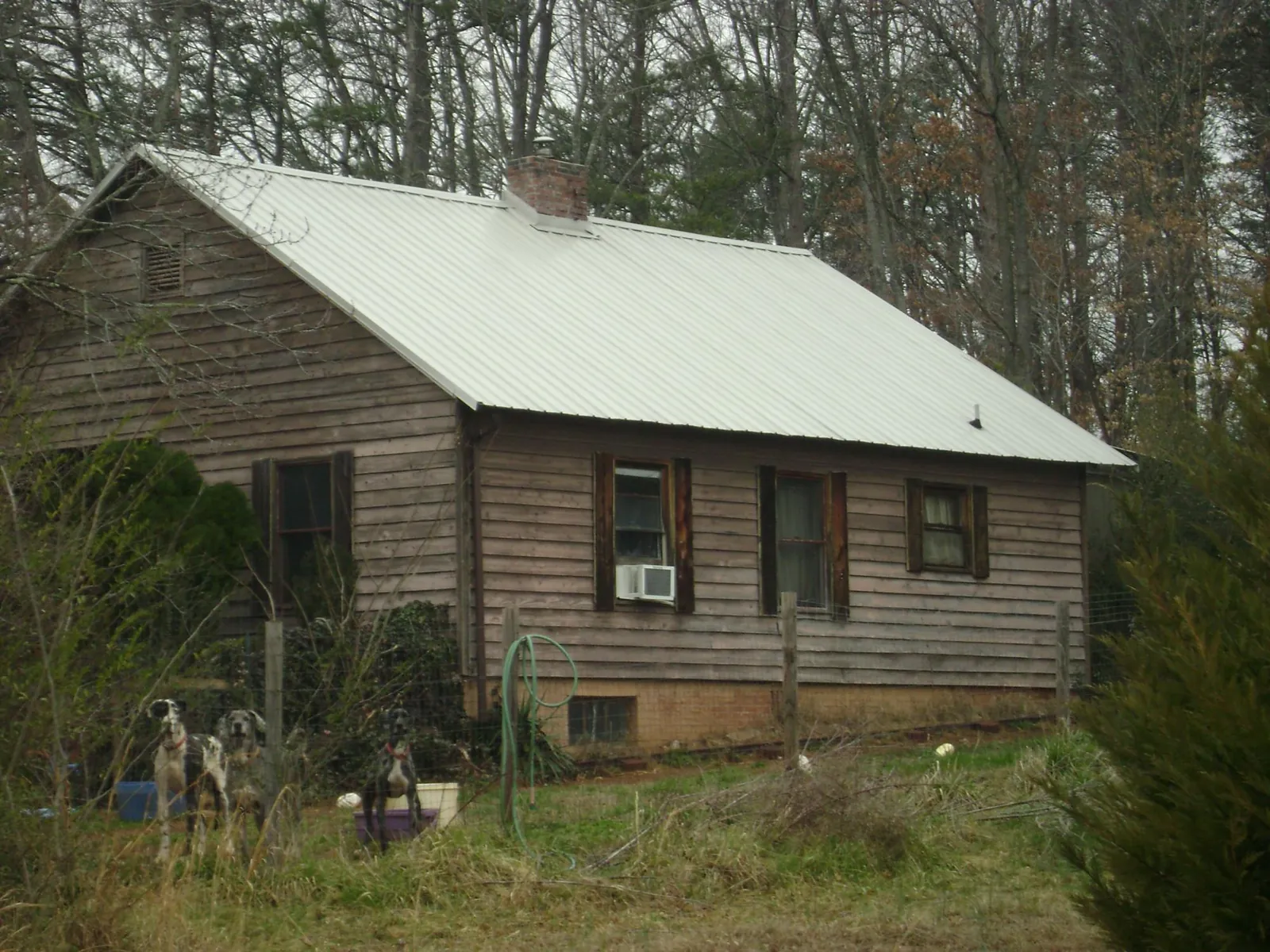 White metal roof on an old wood sided farmhouse, from a Metal Roof Installation job in Skaneateles Falls